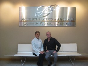 Doctor seating in front of the new sign at office