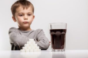 Small boy looking at a soft drink glass