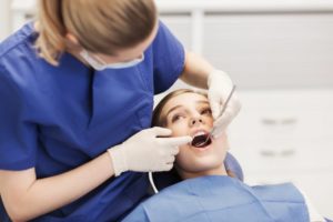 Dentist checking girl's teeth