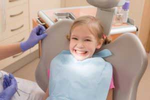 Small girl sitting at the dentist chair