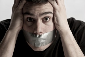 Man covering his mouth with tape